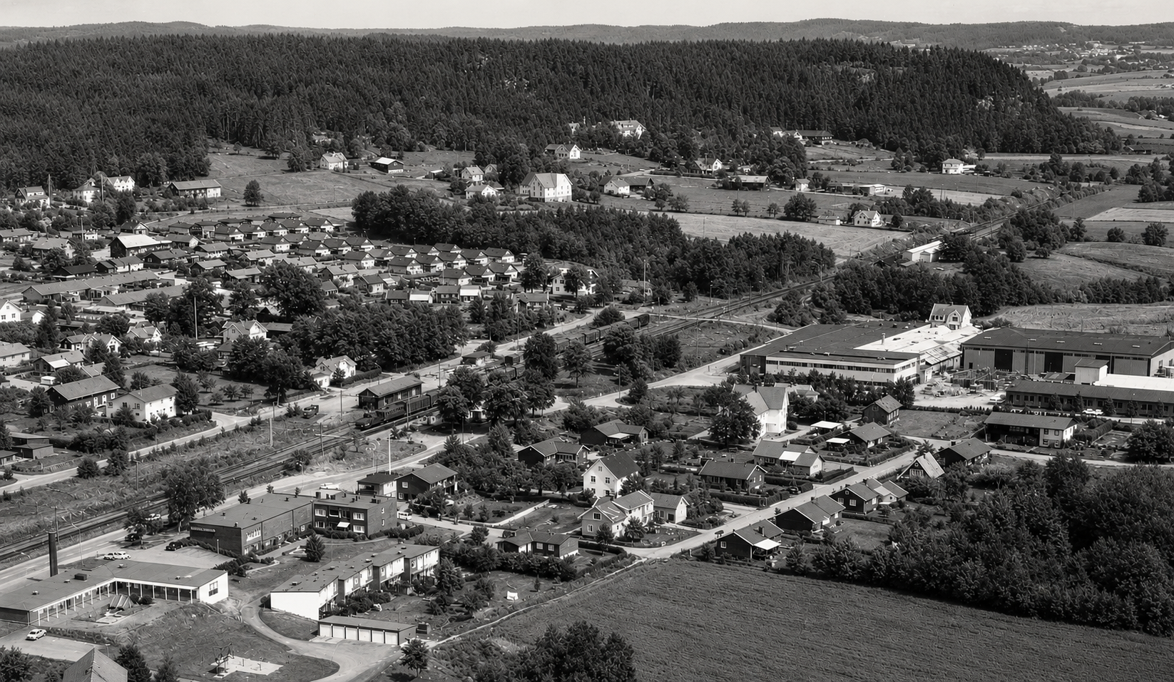 Flygfoto över Rävlanda, med samhället och fabriken i bakgrunden.